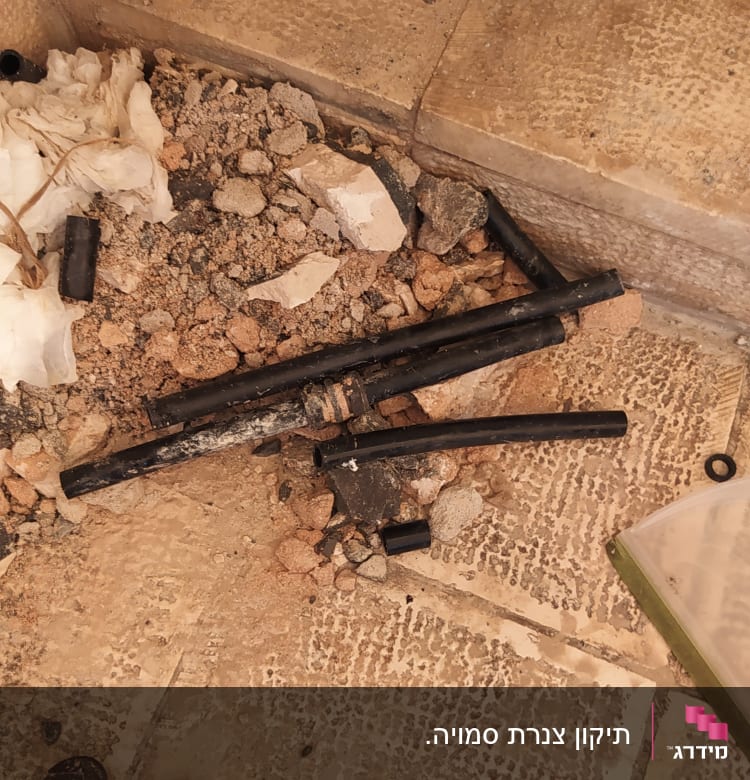 כלי עבודה וצינורות שחורים על רצפה מלוכלכת